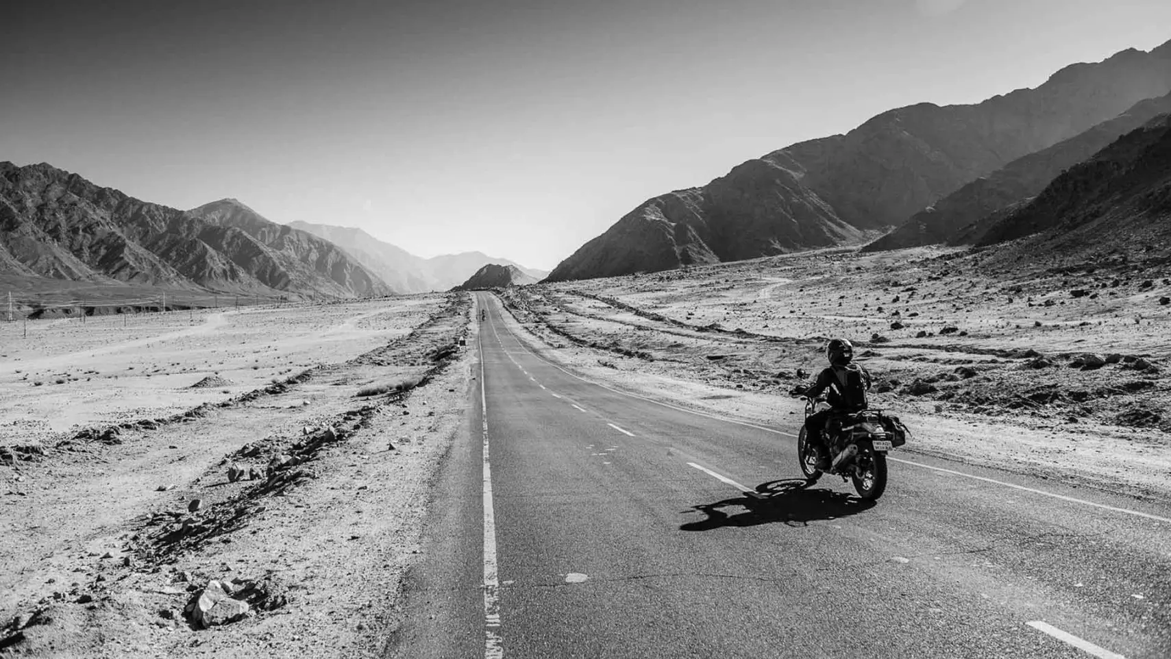 Hombre manejando una moto por la carretera blanco y negro